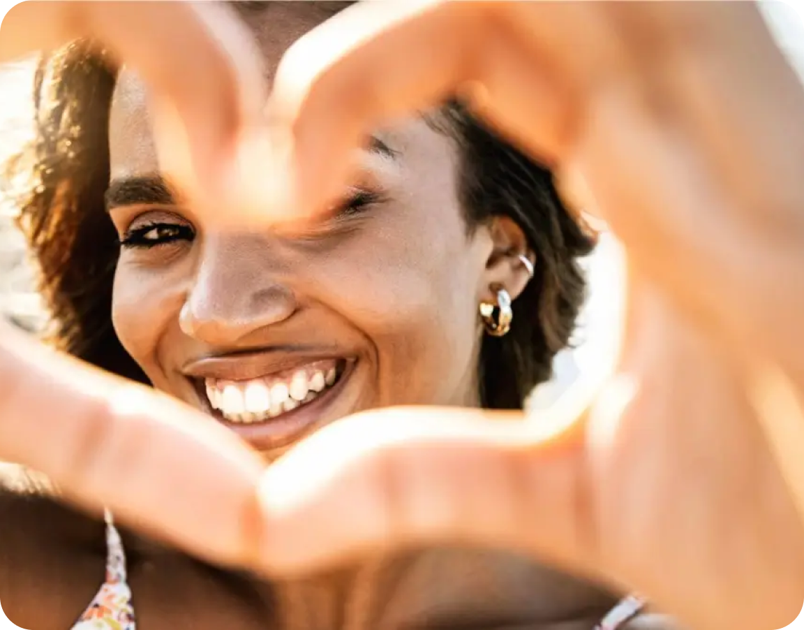 Woman smilling and making a heart with her hands