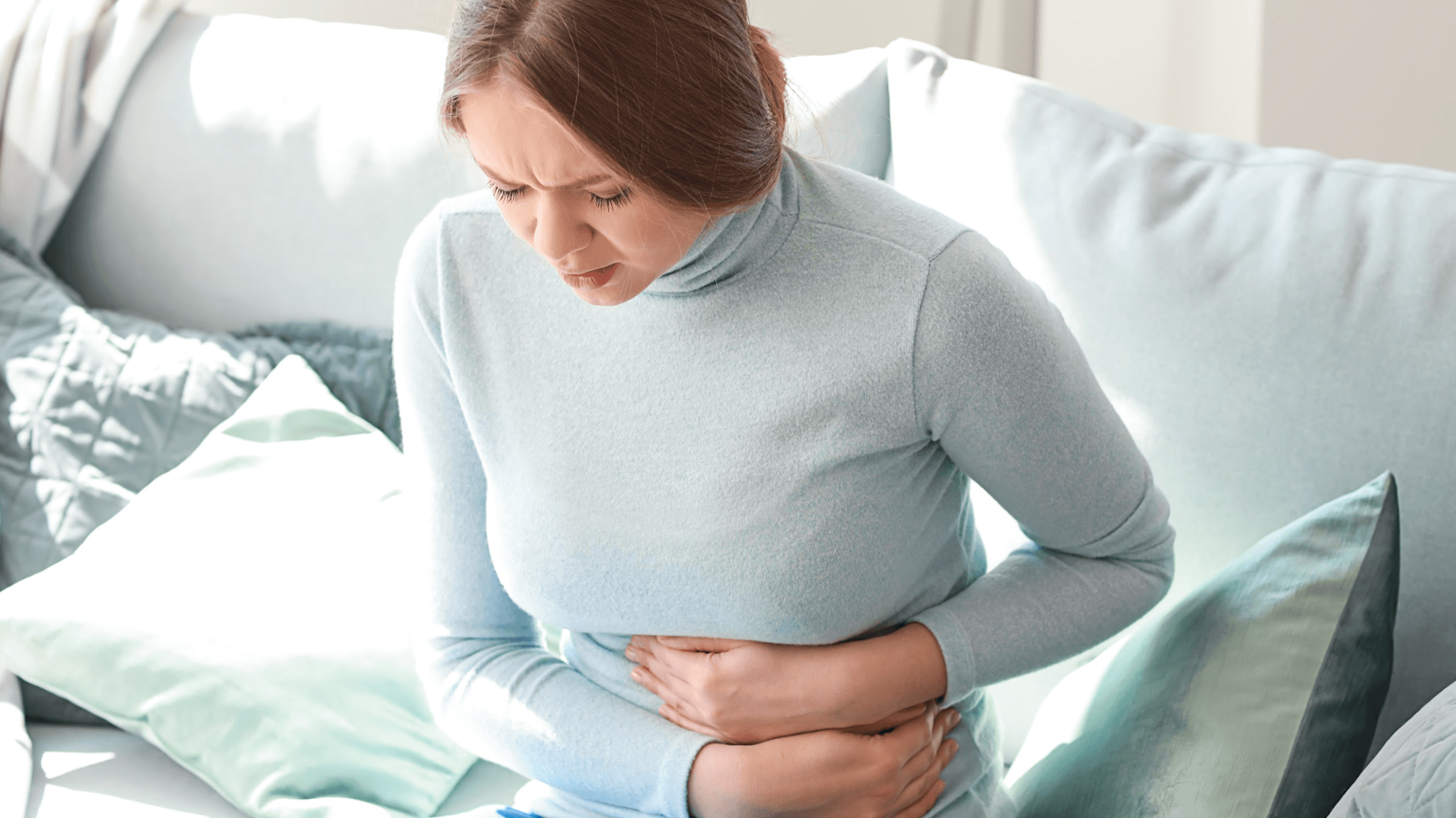 Lady holding her stomach in sign of pain